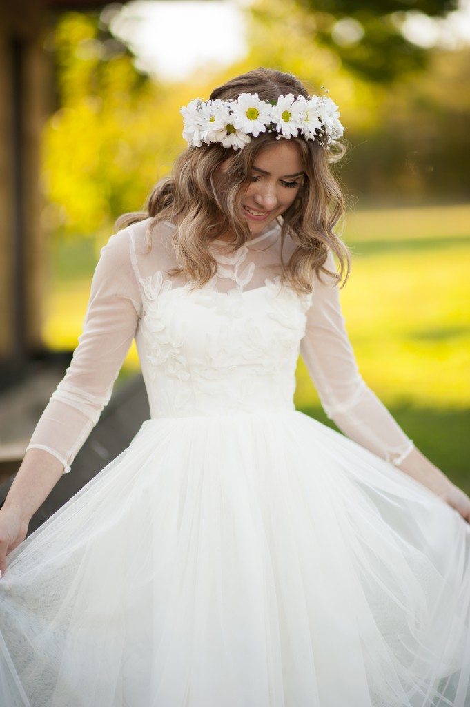 Smiling happy bride poses and enjoys her white dress and floral crown